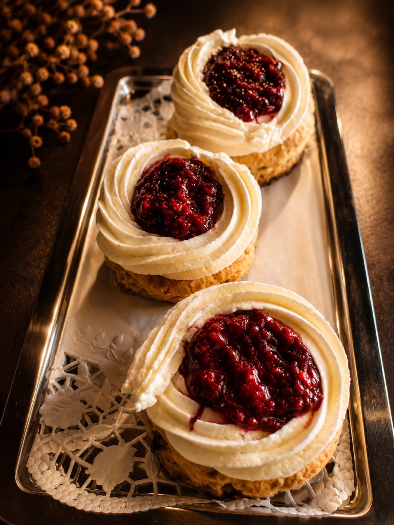Drie scones met clotted cream en huisgemaakte frambozenjam op een zilveren schaal