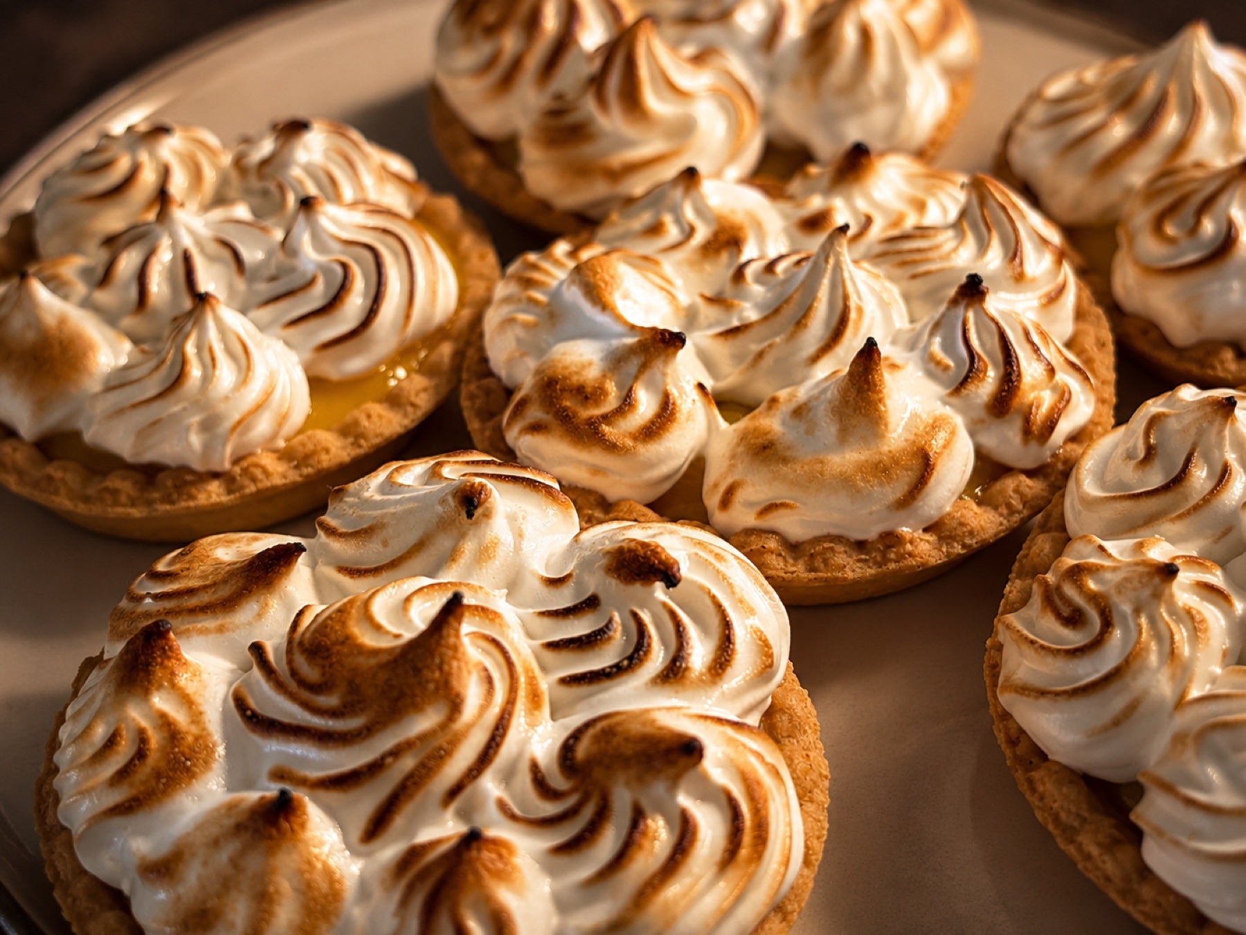 Citroenmeringue-taartjes van dichtbij, met gebrande meringue